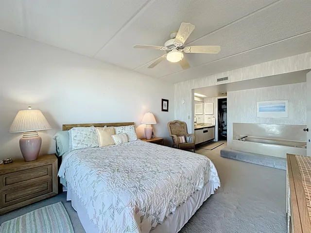 a bedroom with a large bed and a chandelier