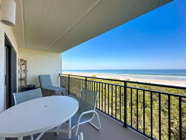 a balcony with table and chairs