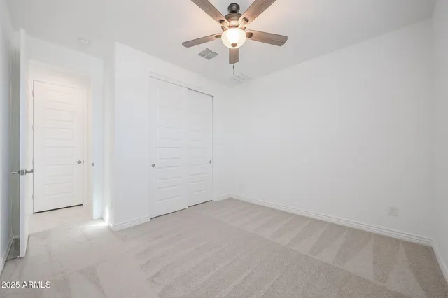 an empty room with a window and a fan