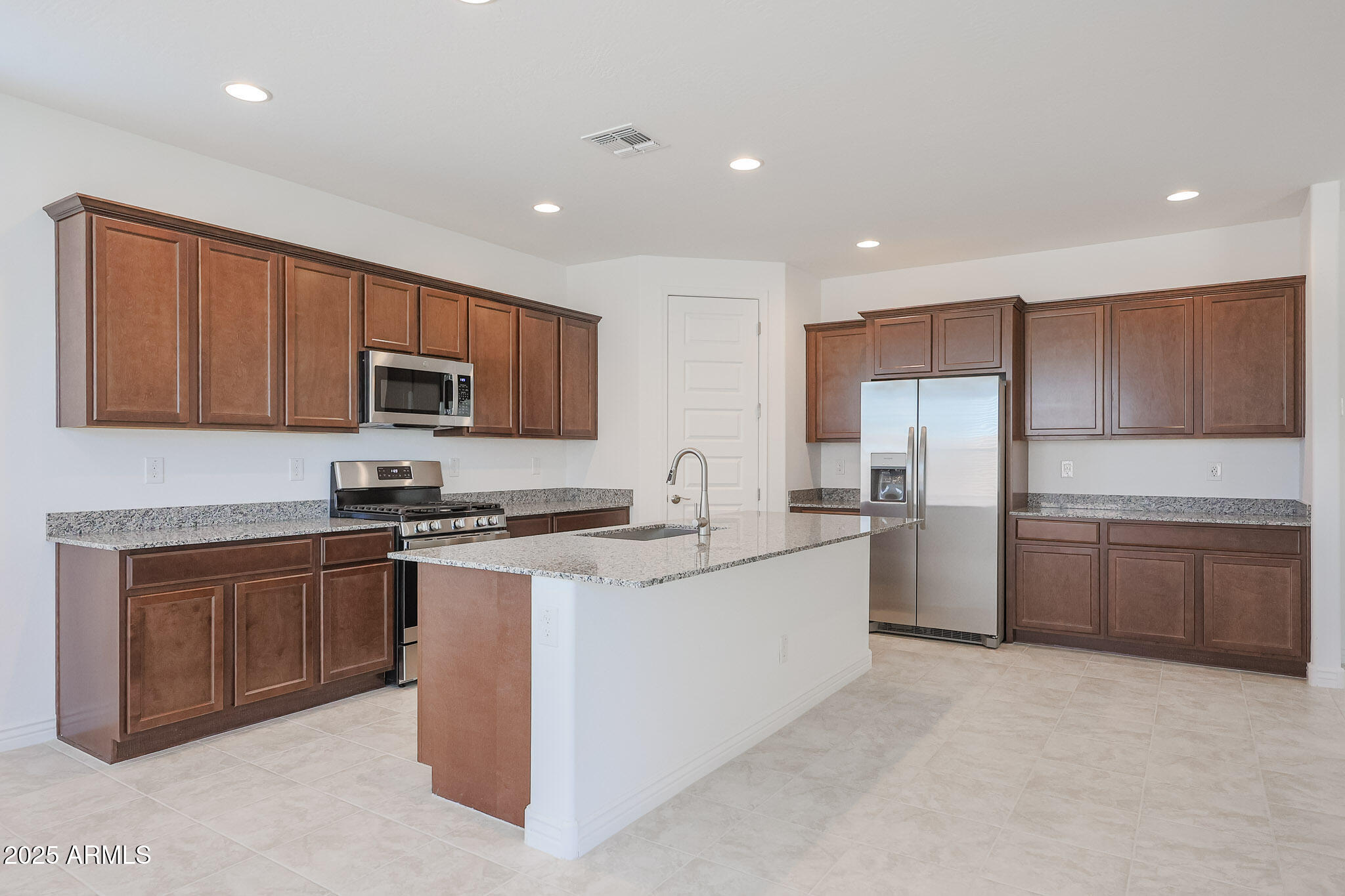25110 North 170th Lane Surprise, AZ 85387 - Photo 2 of 20 a kitchen with stainless steel appliances granite countertop a stove top oven a sink dishwasher and a refrigerator with wooden cabinets