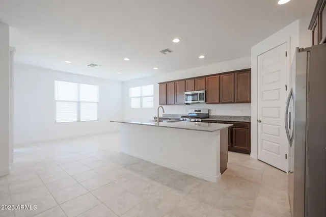 a kitchen with stainless steel appliances granite countertop a refrigerator sink and white cabinets