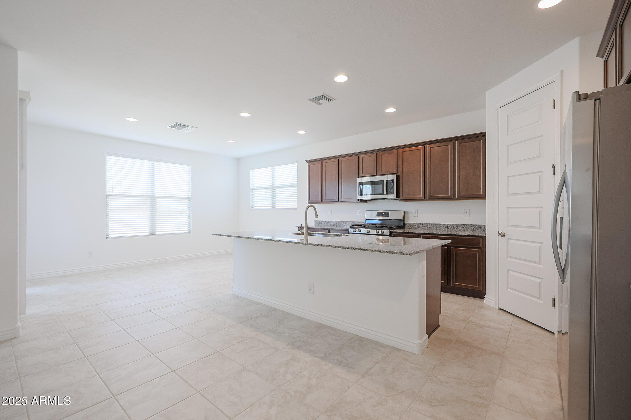 25110 North 170th Lane Surprise, AZ 85387 - Photo 3 of 20 a kitchen with stainless steel appliances granite countertop a refrigerator sink and white cabinets