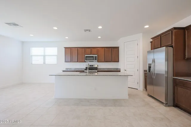 a kitchen with stainless steel appliances a refrigerator sink and cabinets