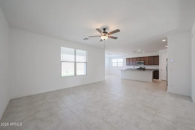an empty room with a window and a ceiling fan