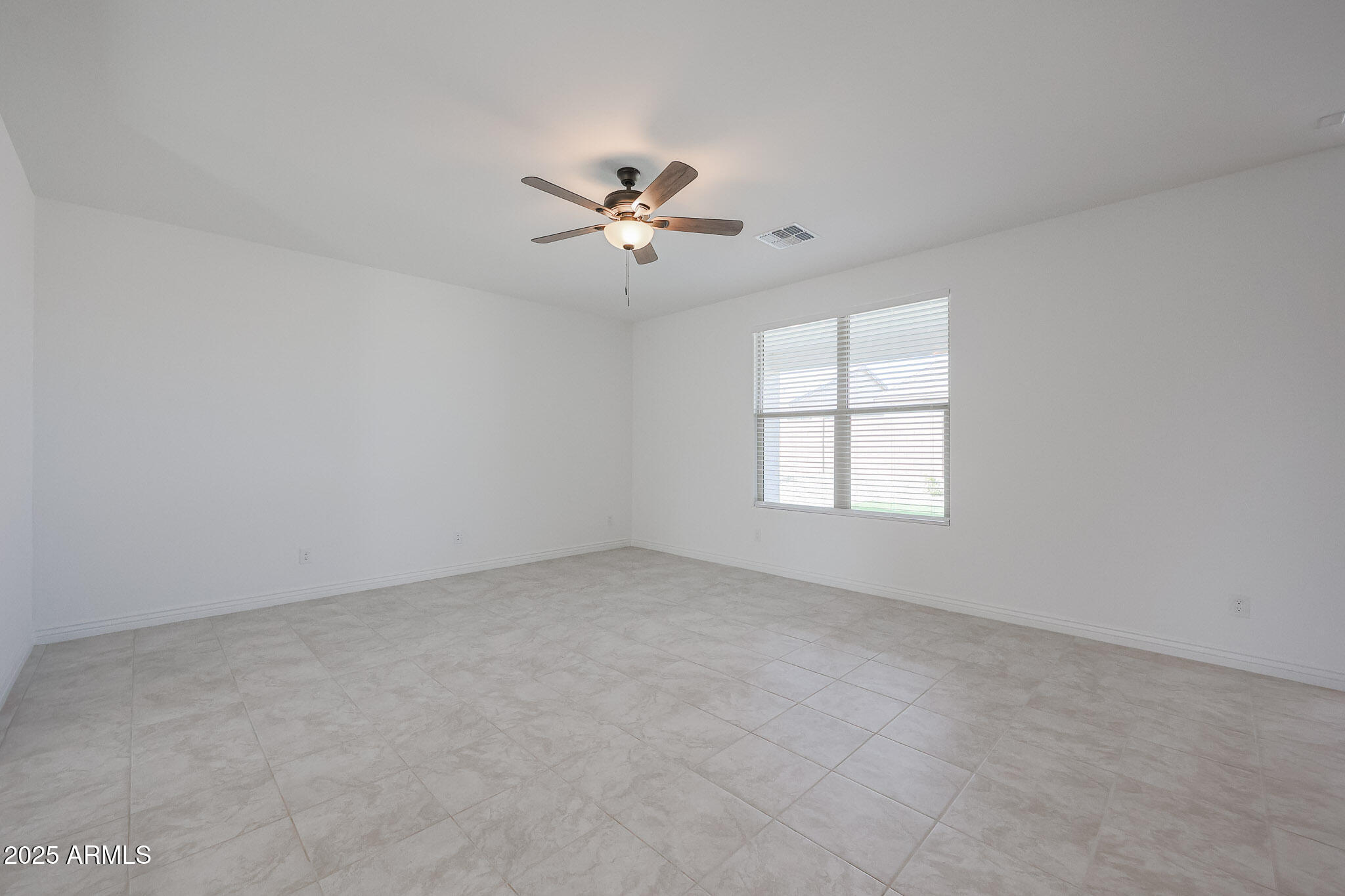 25110 North 170th Lane Surprise, AZ 85387 - Photo 7 of 20 an empty room with a window and a ceiling fan