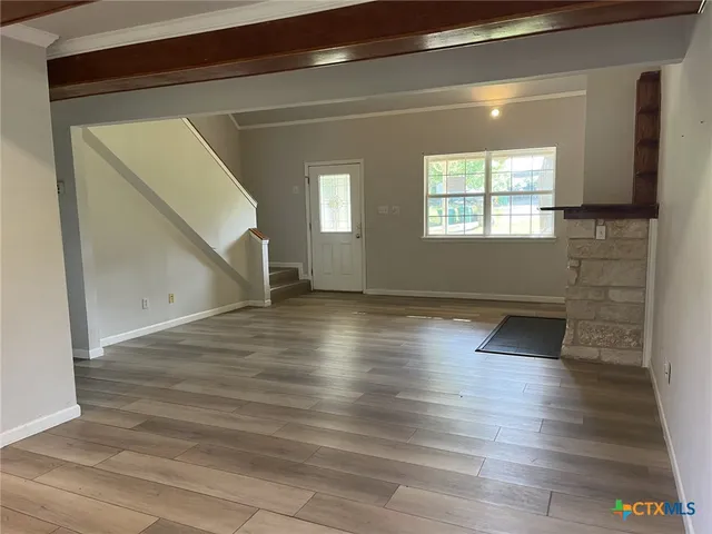 a view of empty room with wooden floor