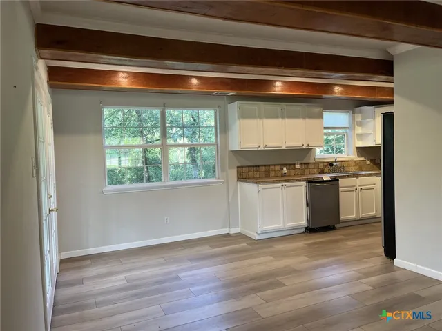 a kitchen with stainless steel appliances granite countertop a stove and a white cabinets