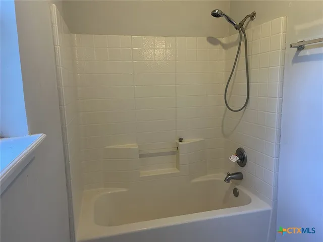 a bathroom with a bath tub with a shower