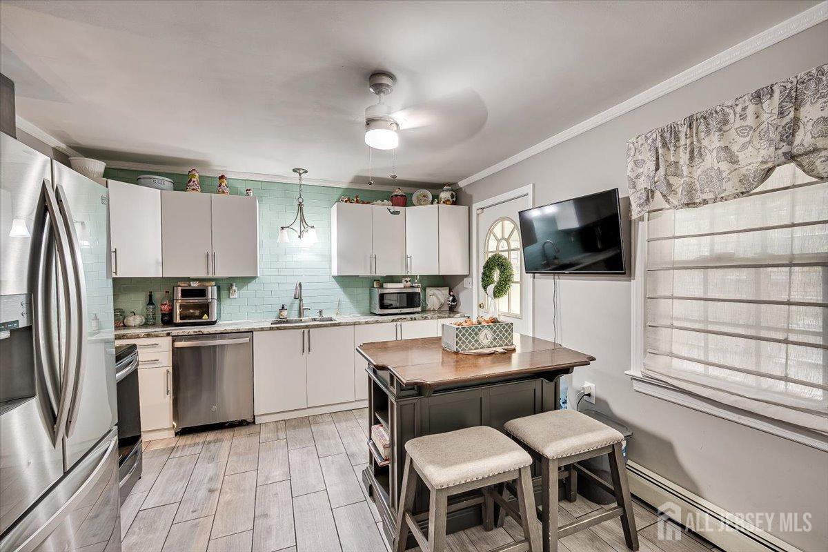 137 5th Street Edison, NJ 08837 - Photo 17 of 52 a kitchen with a dining table chairs stainless steel appliances and cabinets