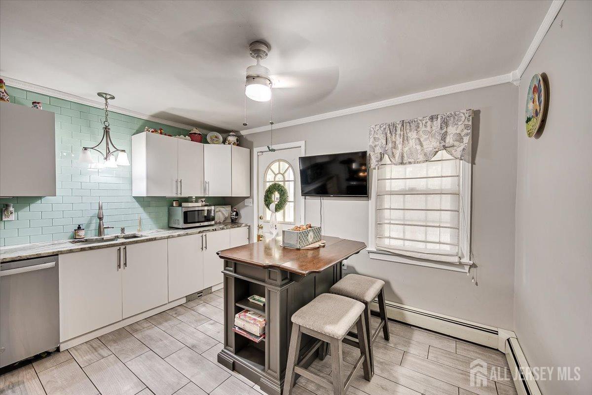137 5th Street Edison, NJ 08837 - Photo 18 of 52 a kitchen with a dining table chairs and white cabinets
