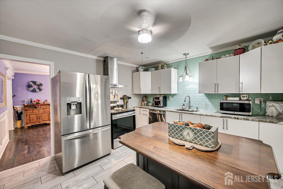 137 5th Street Edison, NJ 08837 - Photo 19 of 52 a kitchen with kitchen island a refrigerator stove and sink