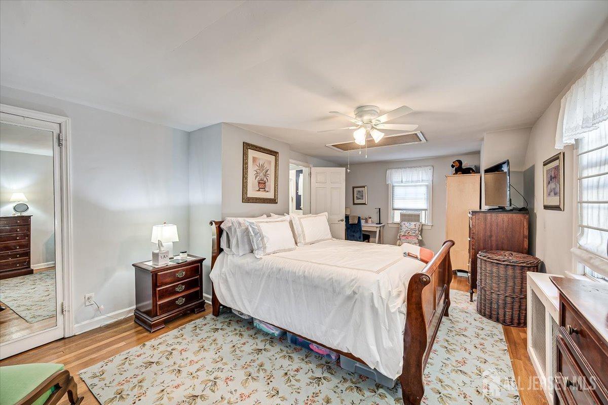 137 5th Street Edison, NJ 08837 - Photo 29 of 52 a bedroom with a bed a chandelier and dresser