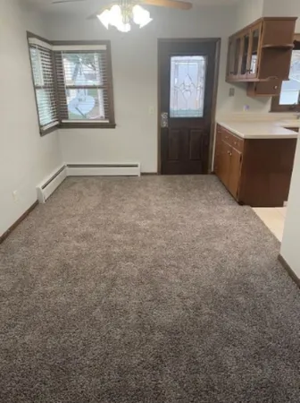 an empty room with windows and cabinet
