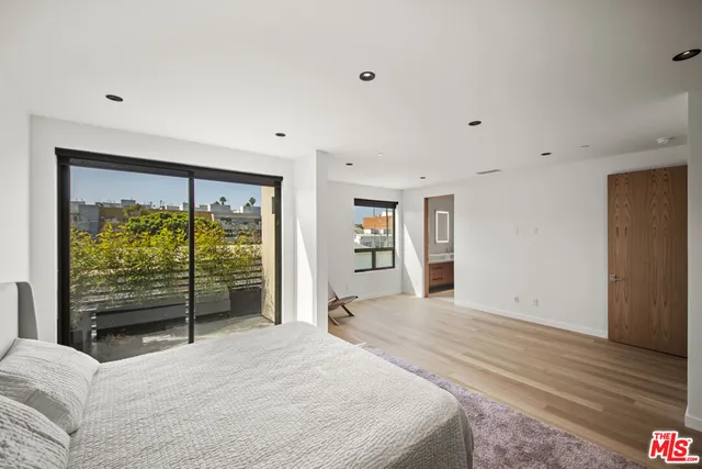 a spacious bedroom with a large bed and a large window