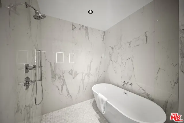 a bathroom with a tub a sink and a shower