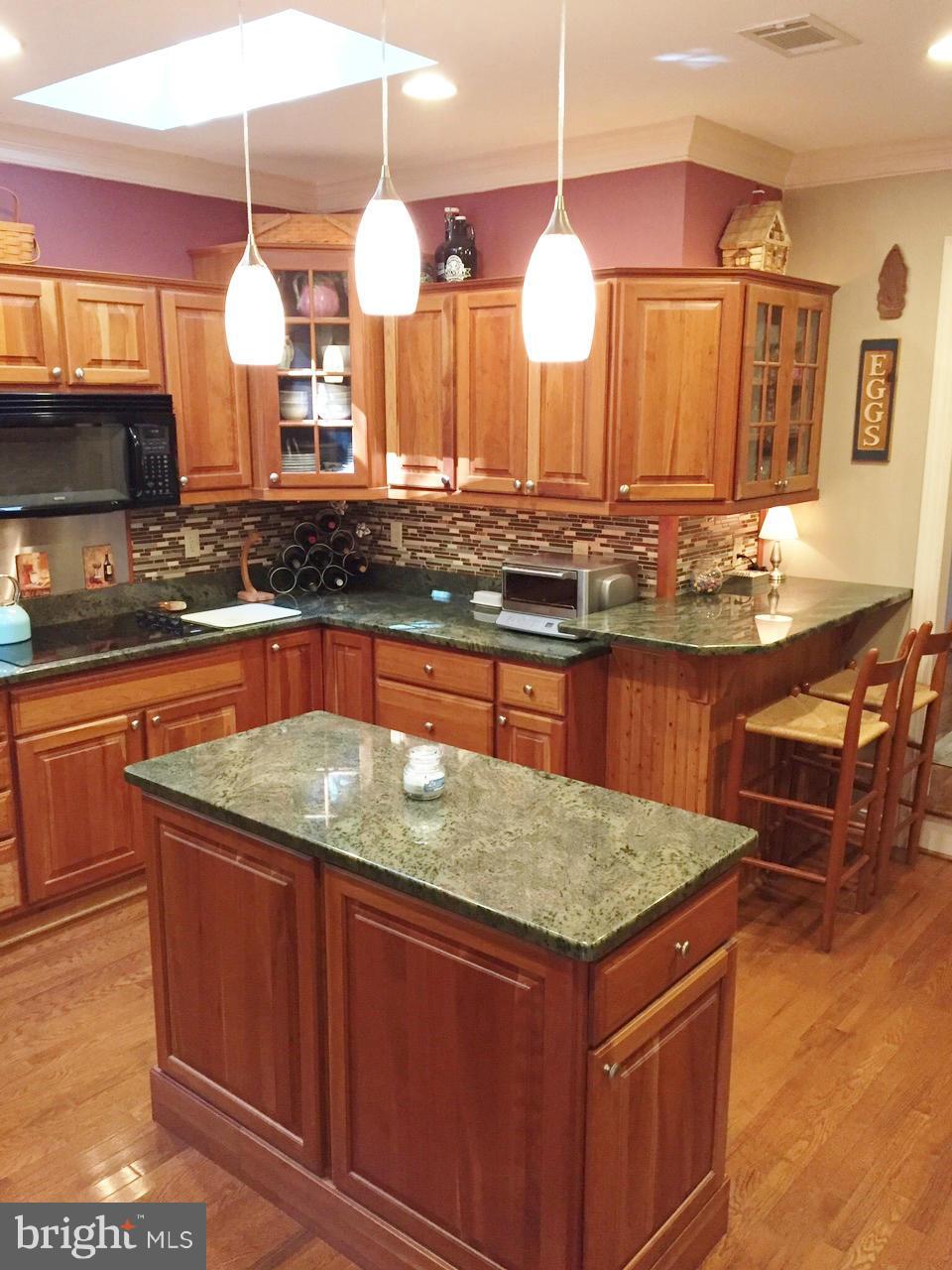 7415 Simms Landing Road Port Tobacco, MD 20677 - Photo 11 of 30 a kitchen with granite countertop a stove a sink and a wooden cabinets