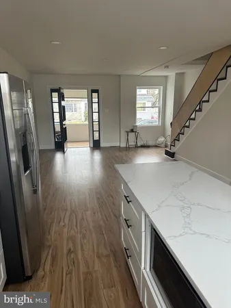a view of a kitchen that shows a sink and wooden floor