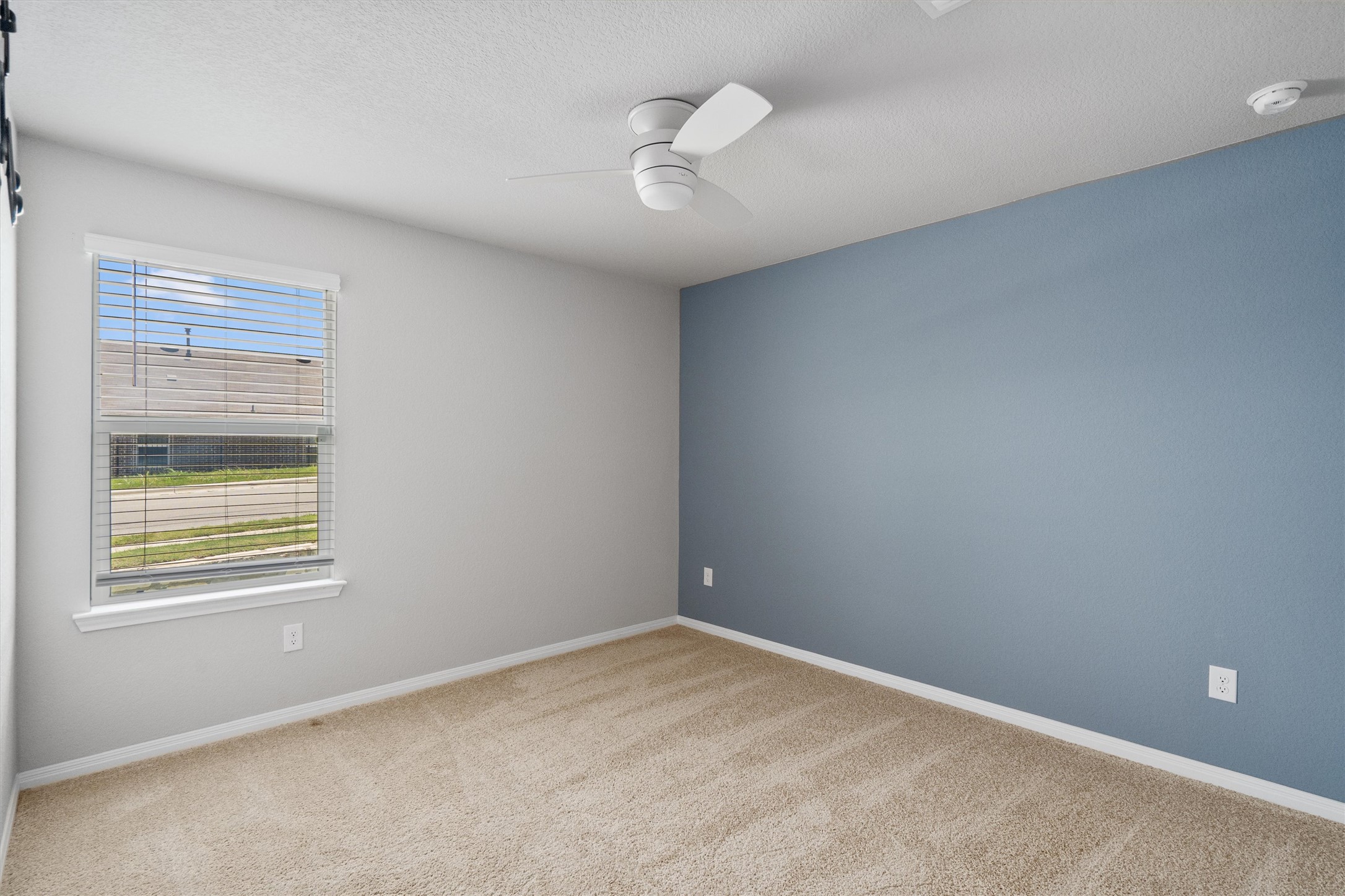 19525 Abigail Fillmore Road Manor, TX 78653 - Photo 22 of 38 A well-lit bedroom with soft carpeting and a contemporary ceiling fan, ready for personal touches.