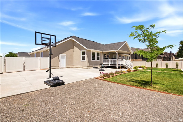 2973 West Red Sand Rd Haven Ogden, UT 84401 - Photo 6 of 30 Expansive backyard featuring a covered patio, manicured lawn, gravel area, and white privacy fencing