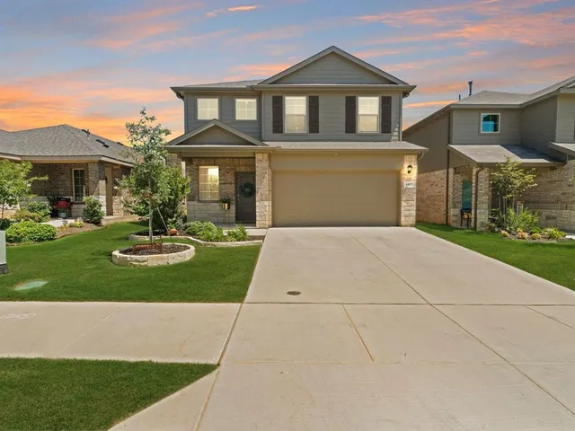 a front view of a house with yard and green space
