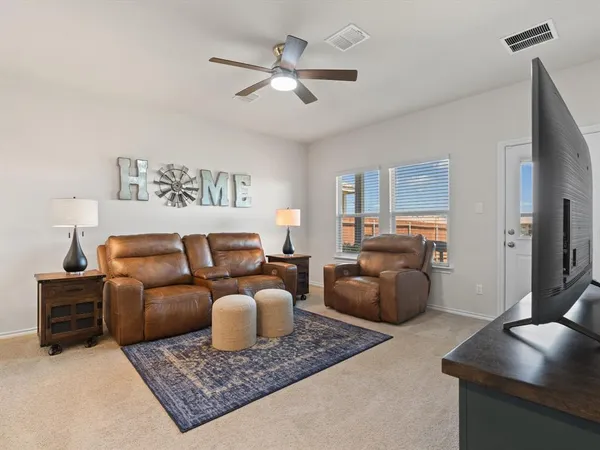 a living room with furniture a rug and a flat screen tv