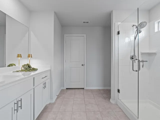 a spacious bathroom with a granite countertop sink a mirror and shower