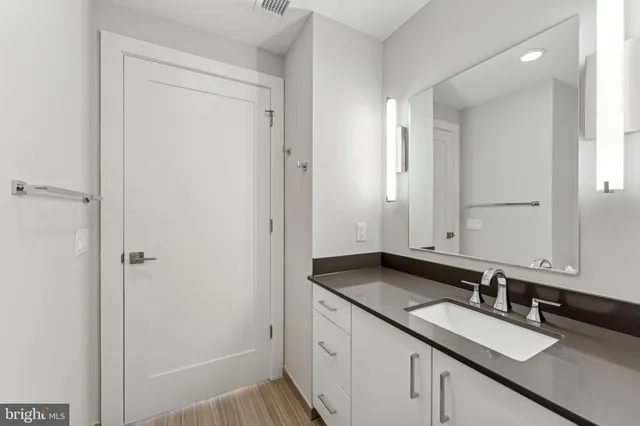 a bathroom with a granite countertop sink and a mirror