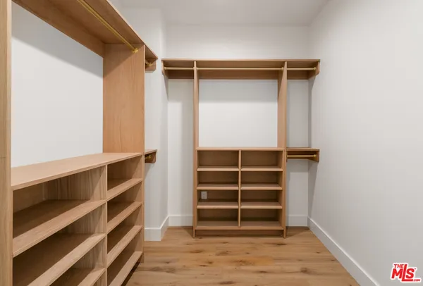 a view of walk in closet with empty racks