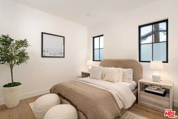 a bedroom with a bed and a potted plant