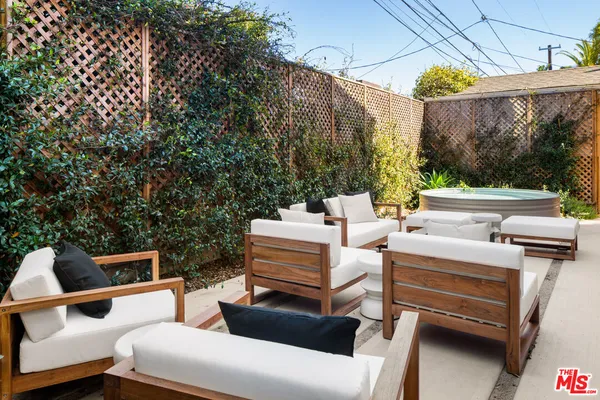 a view of a patio with table and chairs with wooden floor and fence