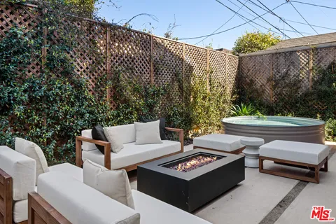 a view of a patio with couches table and chairs and potted plants