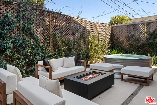 a view of a patio with couches table and chairs and potted plants