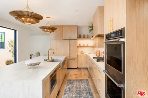 a kitchen with stainless steel appliances granite countertop a sink and stove top oven