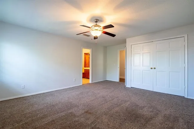a view of an empty room with a ceiling fan