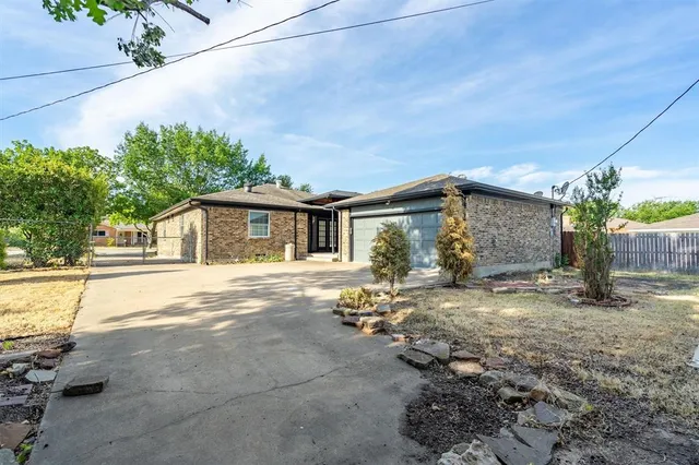 a view of a house with backyard and a tree