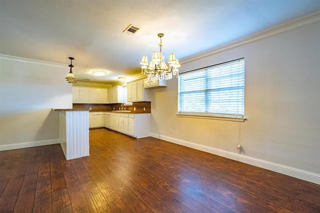 a view of a kitchen with wooden floor and a window
