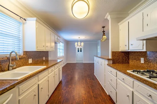 a large kitchen with kitchen island a large counter space a sink stainless steel appliances and cabinets