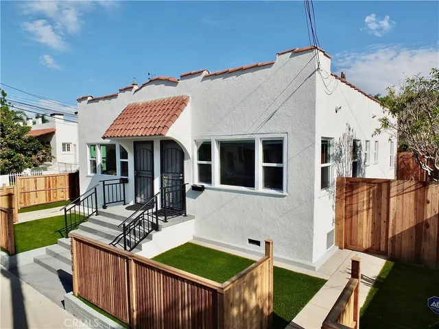 a view of a house with wooden deck and furniture