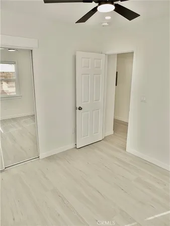 an empty room with fan and entrance