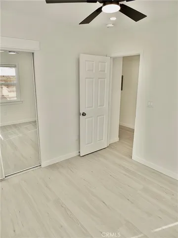 an empty room with fan and entrance