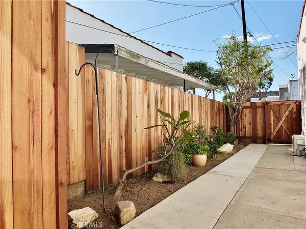 a view of a pathway of a house with wooden fence