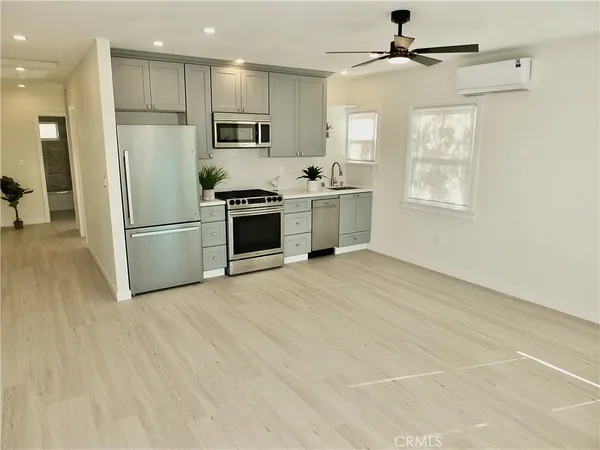 a kitchen with stainless steel appliances a refrigerator sink and microwave