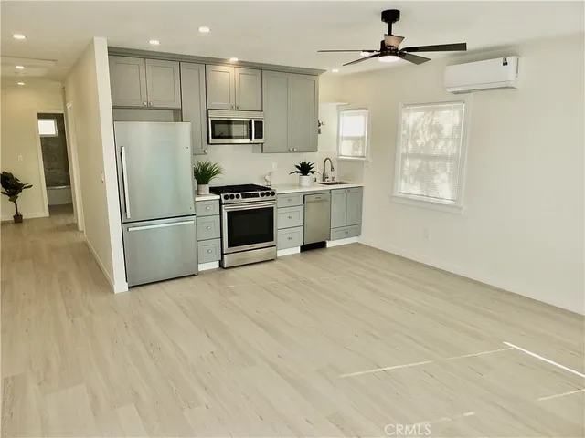 a kitchen with stainless steel appliances a refrigerator sink and microwave