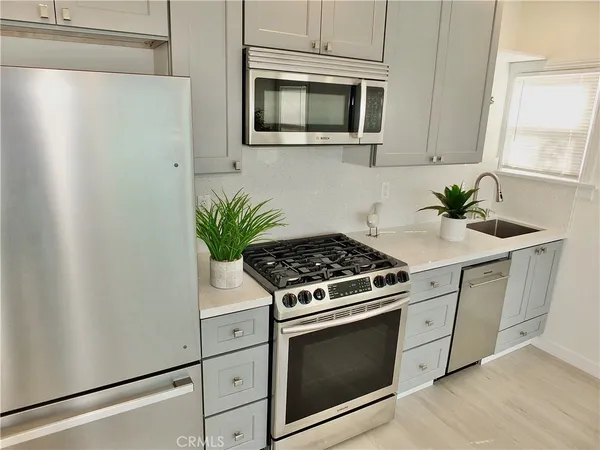 a kitchen with stainless steel appliances white cabinets and a stove top oven