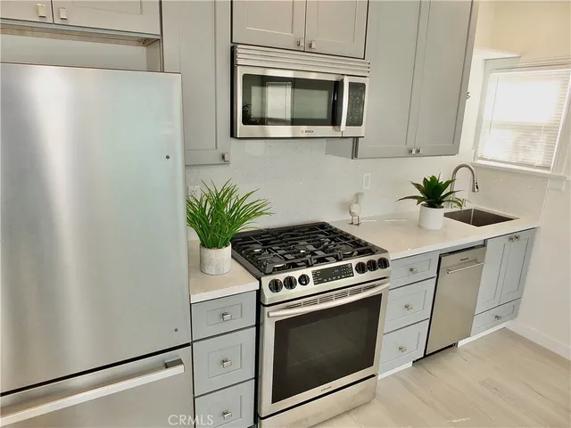 a kitchen with stainless steel appliances white cabinets and a stove top oven