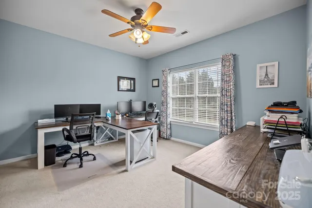a view of a workspace with furniture and a window