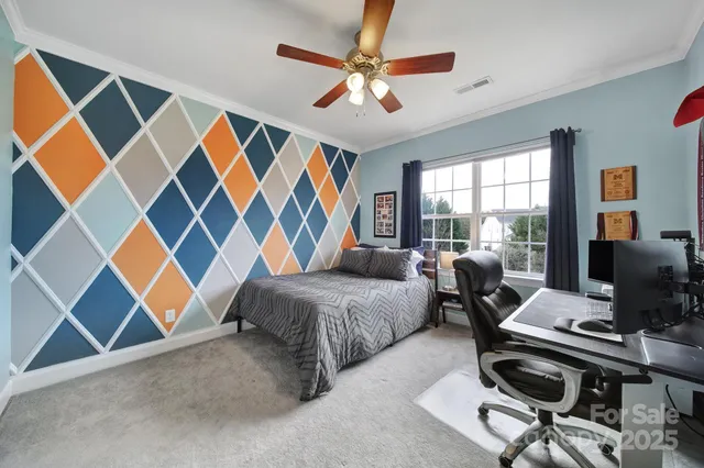 a living room with furniture a chandelier fan and a large window