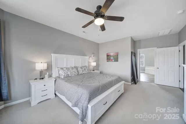 a spacious bedroom with a bed and a flat screen tv