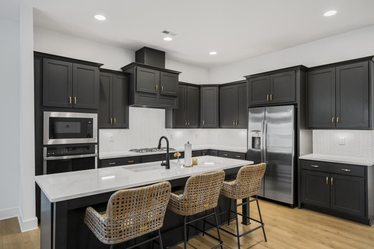 1001 Micato Way Wake Forest, NC 27587 - Photo 10 of 34 a kitchen with kitchen island granite countertop a sink chairs and refrigerator
