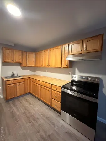 a kitchen with granite countertop a stove a sink and a microwave